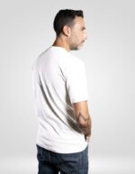 Modelo de perfil con camiseta blanca de algodón orgánico y etiqueta lateral de la marca faaia