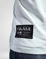Primer plano de la etiqueta corporativa de faaia cosida en el lateral de la camiseta turquesa