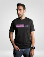 Modelo vistiendo la camiseta negra de faaia con detalles ornamentales en franja de tela fallera fucsia y plata