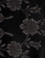 Textura en primer plano de una tela fallera de color negro con un damasco floral brillante