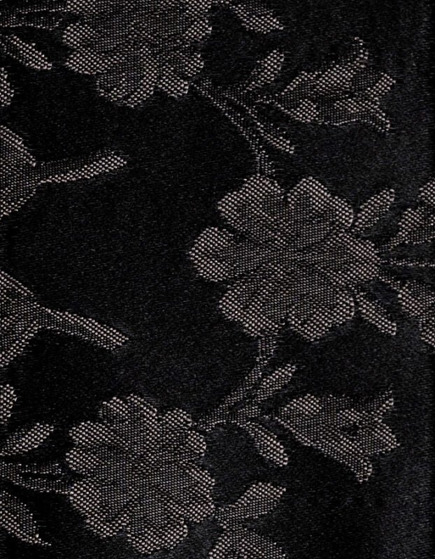 Textura en primer plano de una tela fallera de color negro con un damasco floral brillante