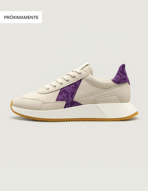 Zapatillas deportivas de piel color beige para mujer con suela blanca y un detalle lateral en color morado confeccionado con tela fallera