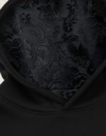 Tela de damasco tejida en telar de Valencia y bordada en el interior de la capucha de una sudadera negra Faaia.
