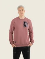 Hombre joven con sudadera de color burdeos de la marca Faaia que lleva un fragmento de damasco como el de las telas falleras en el pecho.