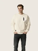 Hombre joven posando con una sudadera regular blanca de la marca Faaia con tela damasco en el pecho.