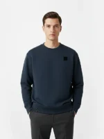 Hombre jovencon el pelo negro posando con sudadera azul marino marca Faaia.