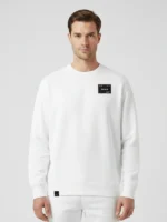 Hombre joven con cabello oscuro posando de frente con sudadera oversize blanca marca Faaia.