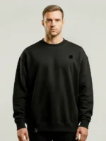 Hombre joven rubio mirando al frente y posando con una sudadera negra marca Faaia.