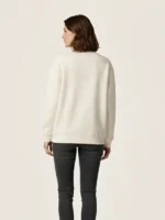 Mujer joven posando de espaldas con una sudadera de la marca Faaia en color blanco.