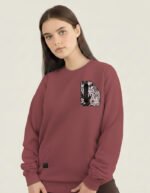 Mujer joven con una sudadera burdeos que lleva insertada tela fallera damasco en el pecho.