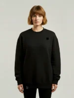 Mujer joven posando de frente con una sudadera negra marca Faaia.