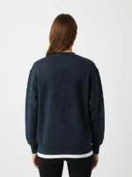 Mujer joven posando de espaldas con una sudadera azul marino marca Faaia