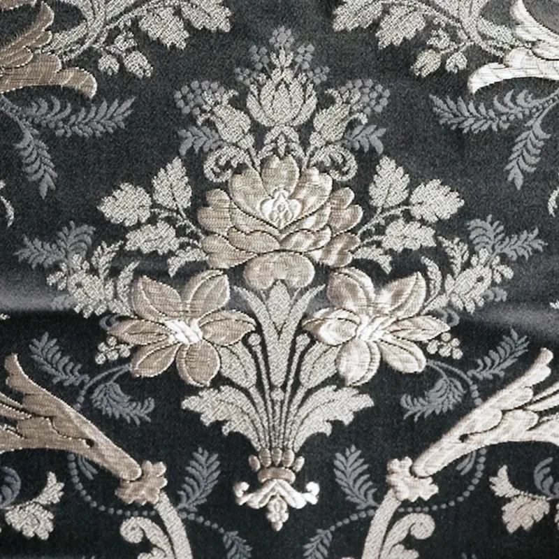 Brocatel Santa Ana en color azul y con hilos plateados generando un dibujo de flor.