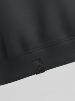 Etiqueta de tela damasco negra aplicada en sudadera de color gris oscuro marca Faaia.