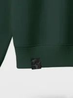 Etiqueta de tela damasco negra aplicada en sudadera de color verde botella marca Faaia.