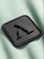 Icono marca Faaia con relieve aplicado en etiqueta de micro inyección negra sobre fondo verde claro.