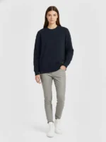 mujer joven posando con una sudadera de la marca Faaia color azul marino.