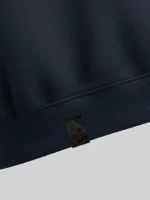 Primer plano de fragmento de tela damasco negra al tono sobre fondo azul marino.