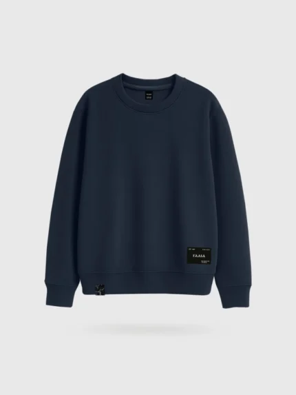 Sudadera azul marino marca Faaia con parche textil en la zona inferior izquierda.