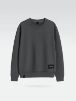 Sudadera gris oscuro marca Faaia con parche textil en la zona inferior izquierda.