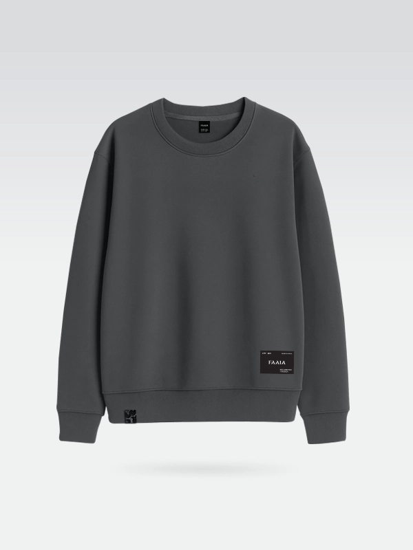 Sudadera gris oscuro marca Faaia con parche textil en la zona inferior izquierda.