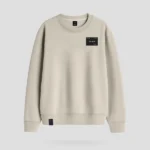 Sudadera color tierra marca Faaia con parche textil con logo de la marca en el pecho.