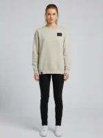 Mujer joven posando mitrando a cámara con sudadera color tierra de la marca Faaia.