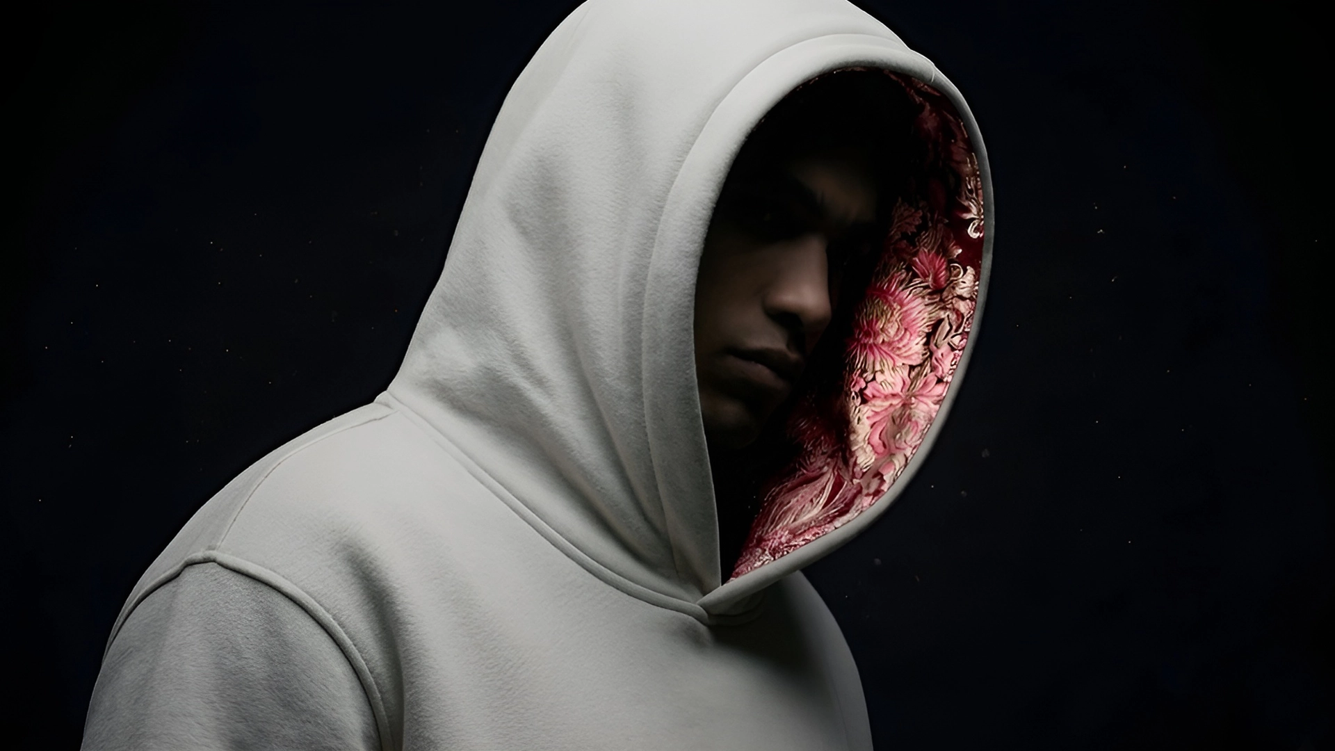 Hombre joven posando con la capucha puesta de la marca Faaia color gris con el interior en brocatel valenciano de color burdeos.
