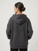 Mujer joven posando con sudadera de la marca Faaia con bordado exclusivo en la espalda y brocatel tejido en telar valenciano en el interior de la capucha.