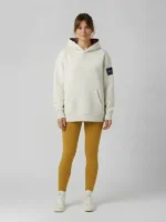 Mujer joven posando con una sudadera de color gris claro con elementos premium y bordados exclusivos.