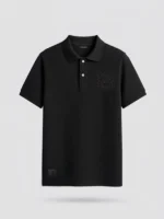 Polo piqué negro con bordado ornamental al tono en el pecho marca Faaia.