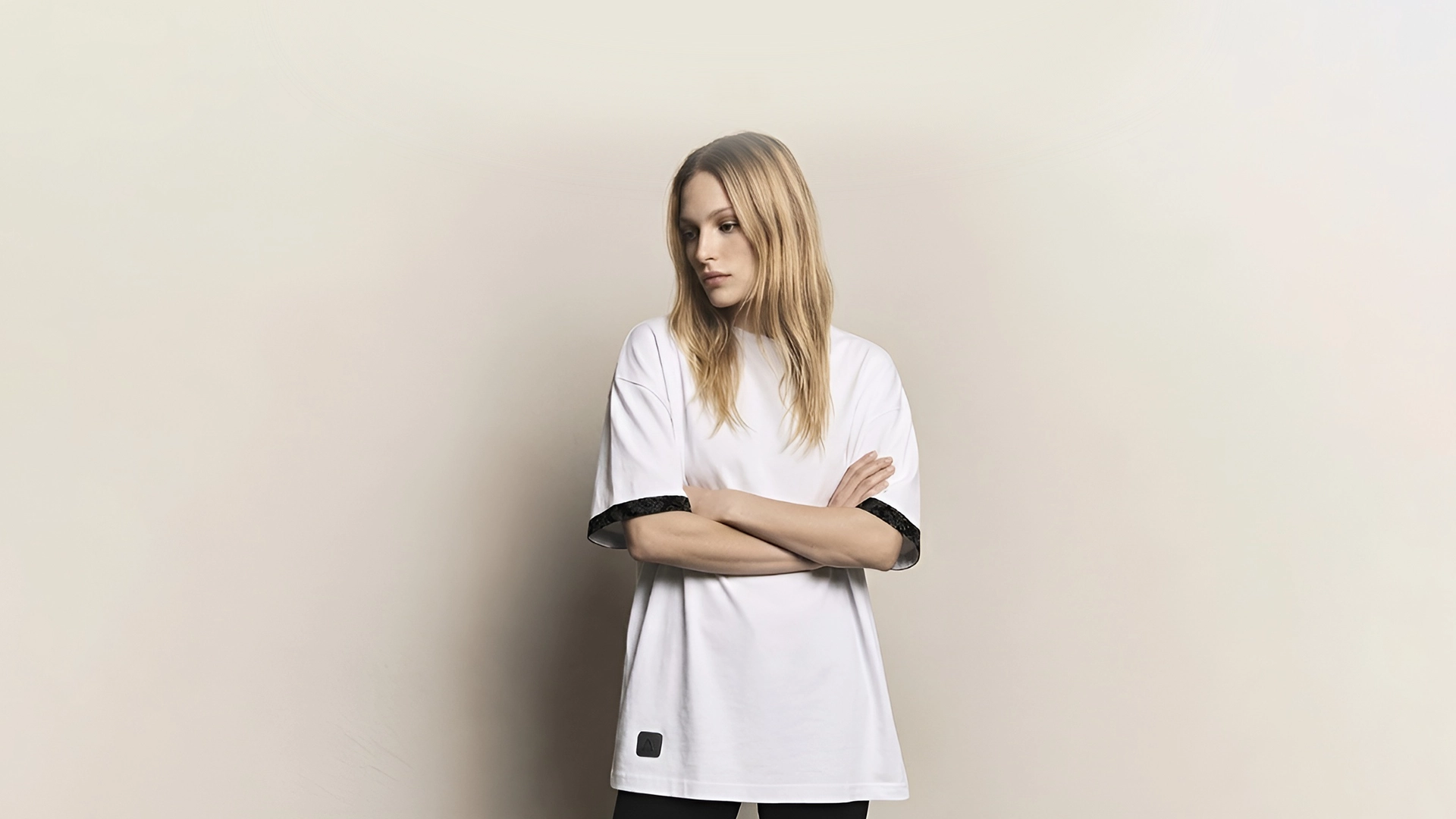 mujer joven posando con camiseta blanca oversize marca Faaia moda con tela damasco en las mangas.