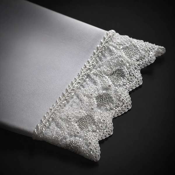 Zoom detallado de puntilla blanca insertada en la manga de una camiseta para mujer oversize color blanco.