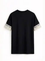 Parte trasera de camiseta negra oversize para mujer que integra puntilla valenciana en las mangas.