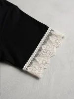 Primer plano de puntilla valenciana blanca, fusionada en las mangas de camiseta para mujeres que buscan elegancia.