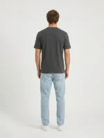 Hombre joven modelo posando de espaldas con una camiseta color gris oscuro.