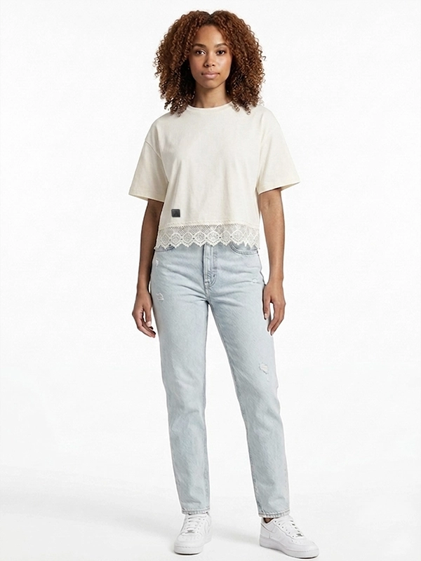 Mujer joven modelo posando con camiseta crop blanca con puntilla.