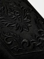 Plano detalle de bordado sofisticado en pantalón corto negro de la marca Faaia.