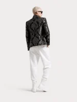 Hombre de espalda posando para la marca Faaia moda con una chaqueta fabricada con brocatel negro y plata.
