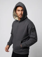 Hombre joven posando con sudadera de la marca Faaia moda con la capucha forrada con un damasco blanco e hilo de oro.