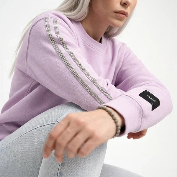 Mujer-joven-posando-arrodillada-con-sudadera-lila-con-pasamaneria-swarozsky-faaia