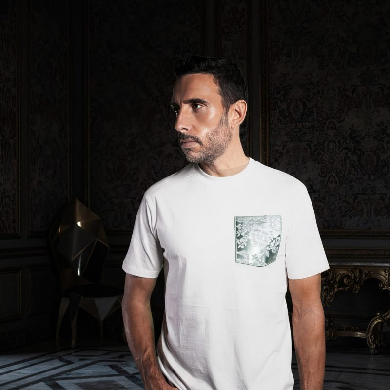 Modelo con camiseta blanca faaia posando de perfil en un interior clásico y elegante con paredes oscuras