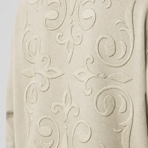 Plano principal del bordado ornamental de una sudadera de color tierra de la marca Faaia.