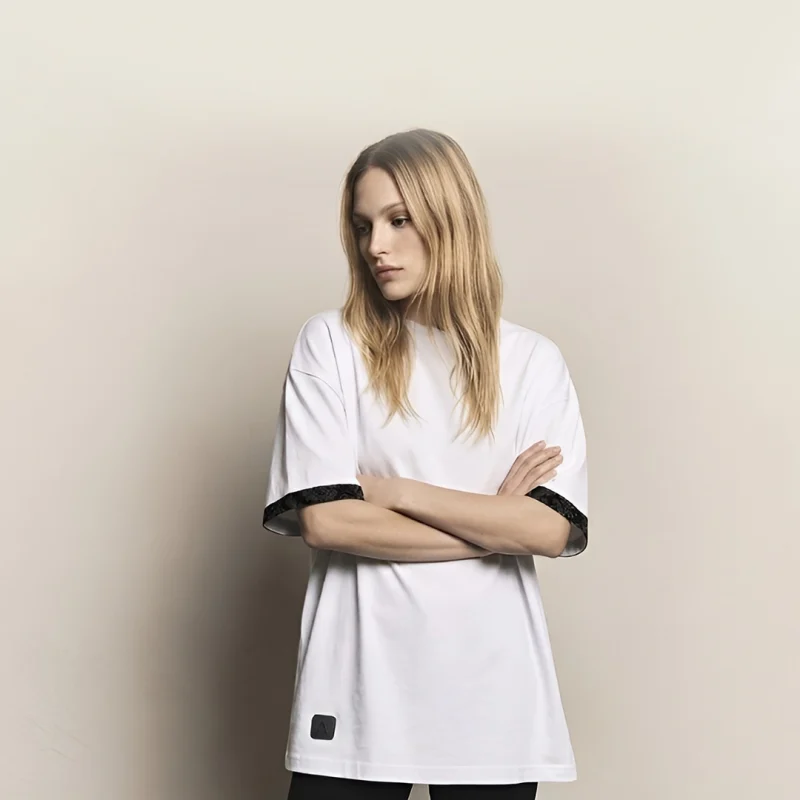 mujer joven posando con camiseta blanca oversize marca Faaia moda con tela damasco en las mangas.